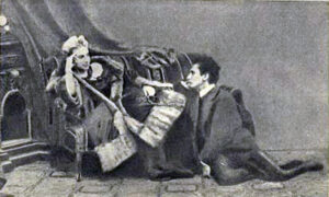 Fanny Pistor sentada segurando um chicote e Sacher-Masoch no chão